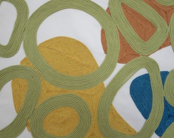 May include: Abstract art featuring overlapping circles in shades of green, yellow, orange, and blue. The circles are made of thick, textured yarn.