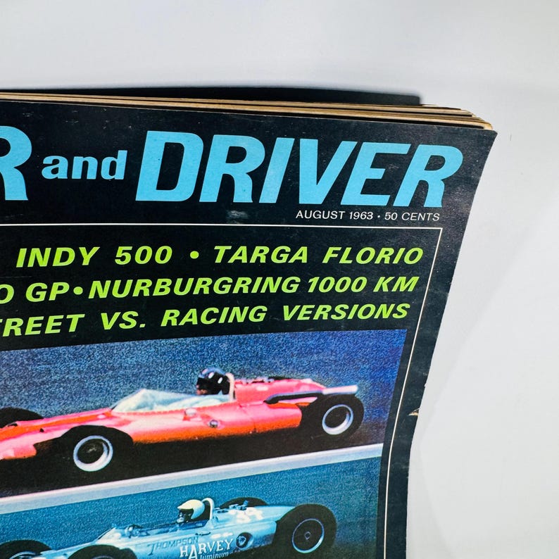 May include: A vintage magazine cover for "R and DRIVER" from August 1963. The cover features a red race car at the top and a blue race car below. The magazine title is in large blue letters, with the issue's date and price visible.