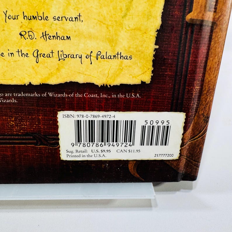 May include: A book with a brown cover and a yellow label. The text on the label reads "Your humble servant, R.D. Henham" and "in the Great Library of Palanthas." The ISBN and barcode are visible.