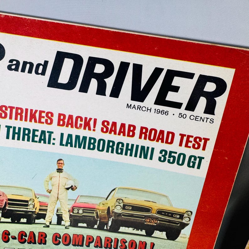 May include: A retro "Car and Driver" magazine cover from March 1966. The cover shows a yellow car, a man in a racing suit, and the headline "Strikes Back! Saab Road Test". The magazine's price is 50 cents.