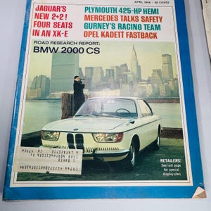 May include: A magazine cover from April 1966 showcasing a white BMW 2000 CS coupe. Headlines include "Jaguar's New 2+2! Four Seats in an XK-E" and "Plymouth 425-HP Hemi." The cover also displays the text "Road Research Report: BMW 2000 CS."