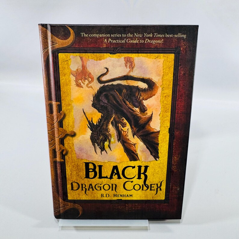 Hardcover copy of Black Dragon Codex by R.D. Henham with brown and gold illustrated dragon cover, shown with fantasy artwork and light visible shelf wear.