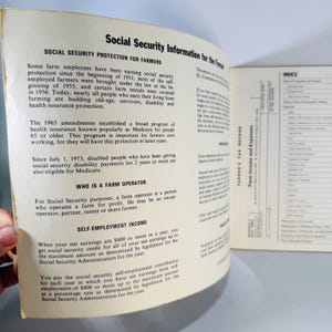 Pu&ograve; includere: Libro aperto con testo sulla Social Security Information for Farmers. Il testo include informazioni sulla protezione della sicurezza sociale, Medicare e reddito da lavoro autonomo. Il libro &egrave; aperto su una pagina con testo e un indice.