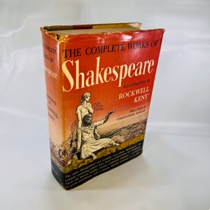 May include: A red hardcover book titled "The Complete Works of Shakespeare" illustrated by Rockwell Kent. The cover features a painting of two figures in a landscape setting.
