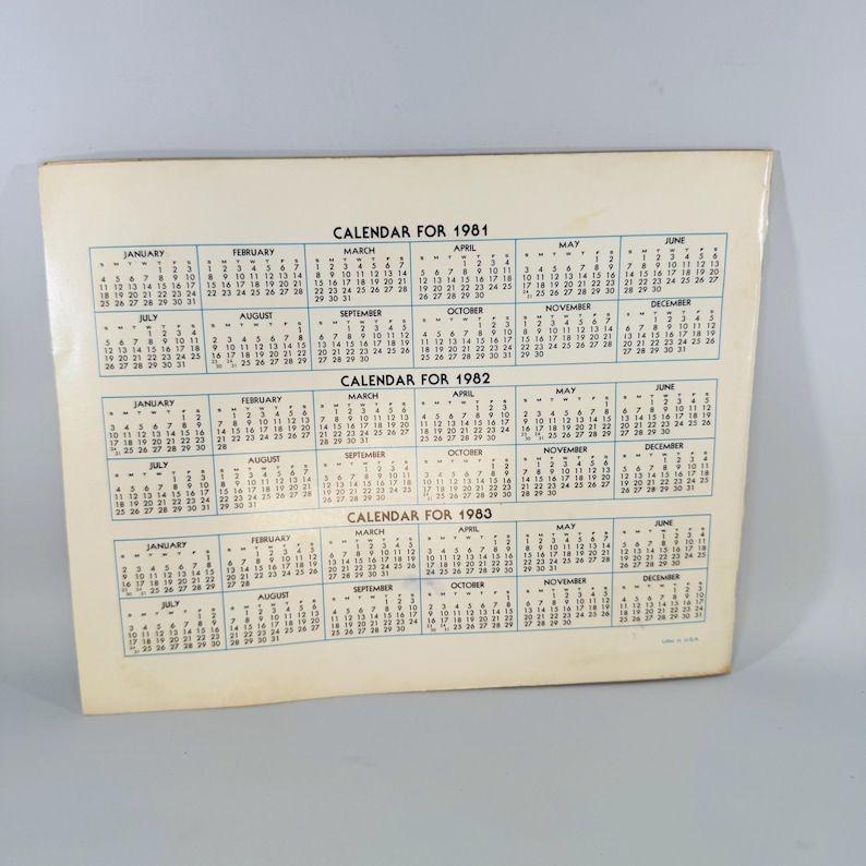 Pu&ograve; includere: Un calendario vintage per gli anni 1981, 1982 e 1983. Il calendario &egrave; stampato su carta color crema e presenta un layout semplice con i mesi e i giorni della settimana. Il testo "CALENDAR FOR" &egrave; stampato in alto.