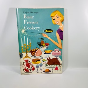 May include: A vintage cookbook cover with a blue background featuring a woman holding a magic wand. The text reads "it's just like magic... Basic Freezer Cookery by Amana". The cover also features a table setting with a variety of food items, including a roasted turkey, ham, and a cake.