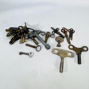 May include: A collection of antique keys and clock keys in various shapes and sizes. The keys are made of metal and show signs of age, with a range of colors from silver to bronze. Some keys are on a ring.