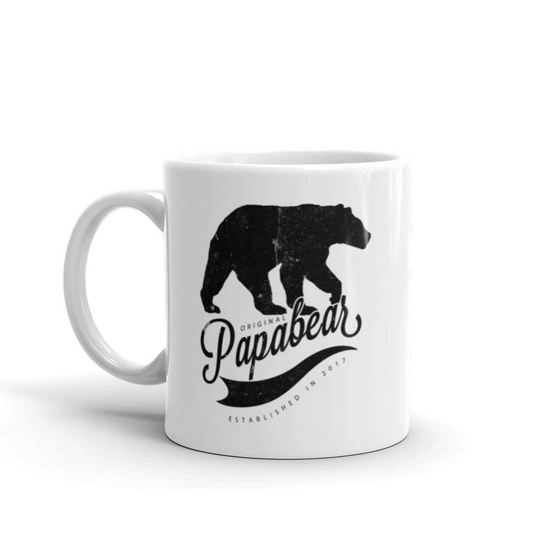 May include: White ceramic mug with a black silhouette of a bear and the text "Original Papabear Established in 2017".