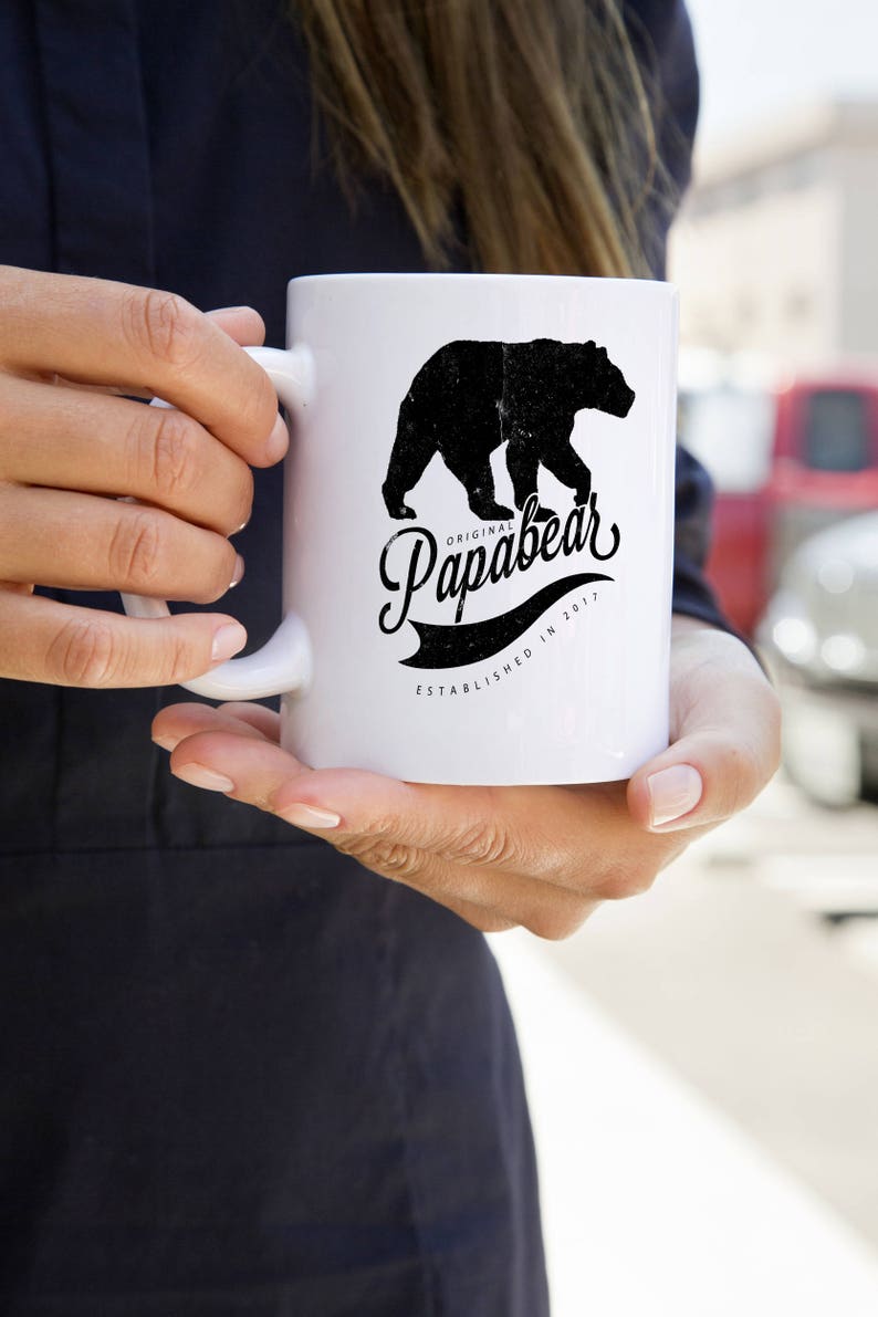 May include: White ceramic mug with a black silhouette of a bear and the text "Original Papabear Established in 2017".