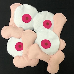 May include: A set of eight pink and white fabric pillows with a red circle in the center of each white pillow.