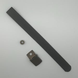 May include: A black leather strap with a metal clasp and a metal ring. The strap is about 12 inches long.