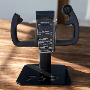 May include: Black airplane yoke with a control panel and a base with the number 757. The yoke has two curved handles and a central panel with text including "BEFORE TAKEOFF" and "AFTER TAKEOFF".
