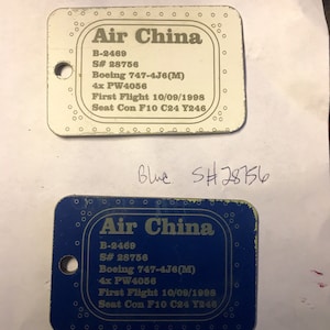 K&ouml;nnte beinhalten: Zwei blaue und wei&szlig;e Plastik-Flugtickets mit dem Text "Air China" und den Flugdetails: B-2469, S# 28756, Boeing 747-4J6(M), 4x PW4056, Erstflug 10/09/1998, Sitz Con F10 C24 Y246.