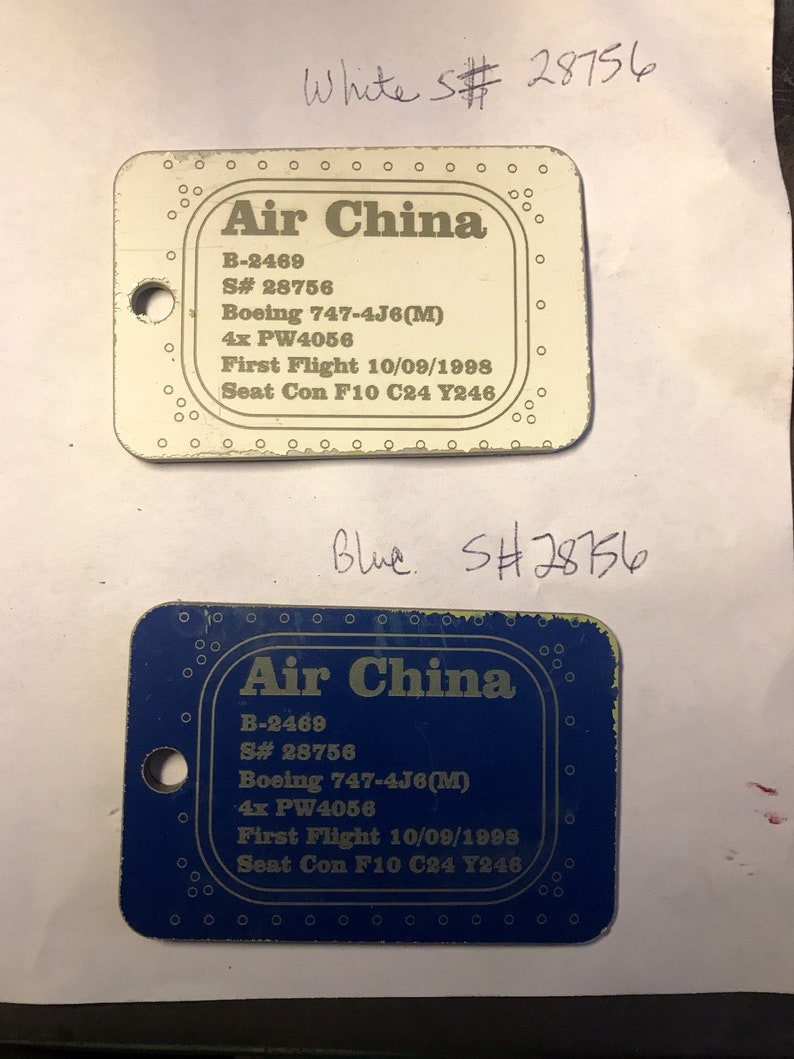 K&ouml;nnte beinhalten: Zwei blaue und wei&szlig;e Plastik-Flugtickets mit dem Text "Air China" und den Flugdetails: B-2469, S# 28756, Boeing 747-4J6(M), 4x PW4056, Erstflug 10/09/1998, Sitz Con F10 C24 Y246.