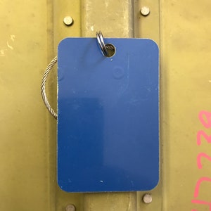 K&ouml;nnte beinhalten: Ein blaues Metallschild mit einem silbernen Ring. Das Schild ist leer und kann personalisiert werden.