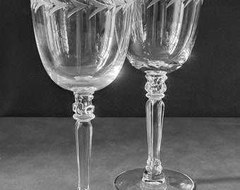 May include: Two clear wine glasses with etched chevron designs near the rim. The glasses have long stems and round bases. The text "2hippiesvintage" is at the bottom of the image.