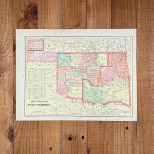May include: A vintage map of Oklahoma and the Indian Territories, showing the state's counties and surrounding areas. The map is printed on aged paper with a palette of greens, pinks, and yellows. Measurements are not available.