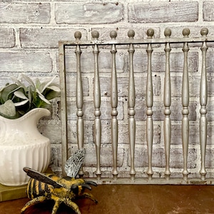 May include: A silver metal decorative wall panel with a grid of vertical bars. The panel has a rustic, distressed look and is perfect for adding a touch of farmhouse style to any room.