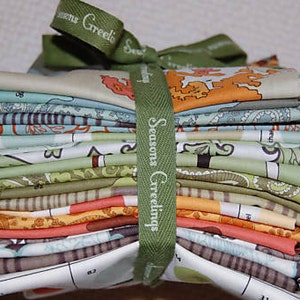 Könnte beinhalten: Ein Stapel Stoffquadrate mit Mustern in verschiedenen Farben, darunter Grün, Orange und Blau, gebunden mit einem grünen Band mit der Aufschrift "Seasons Greetings". Der Stoff hat Blumen- und Kartenmuster.