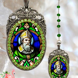 May include: A silver and green rosary necklace with a pendant featuring a stained glass image of Saint Patrick. The pendant is surrounded by green rhinestones.