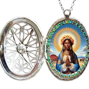 Può includere: Collana con ciondolo in argento con un bordo di pietre preziose verdi e blu. Il ciondolo si apre per rivelare un'immagine colorata di una donna con un'aureola, che indossa un abito blu e dorato.