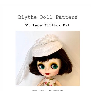 May include: A white pillbox hat with a white flower accent, designed for a 12-inch Blythe doll. The hat is worn by a doll with brown hair and green eyes. The image includes the text "Blythe Doll Pattern Vintage Pillbox Hat Skill Level: Intermediate Step-by-Step PDF Sewing Tutorial & Pattern Designed to fit 12" Dolls Betty Allan Designs Barbara Allan McGinty © 2021".