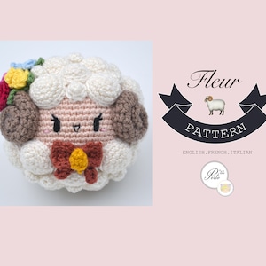Peut inclure: Un mouton en amigurumi crocheté avec un visage rose, des oreilles brunes et un nœud rouge et jaune. Le mouton porte une couronne de fleurs avec des fleurs rouges, jaunes et bleues. L'image comprend le texte "Fleur Pattern English, French, Italian"