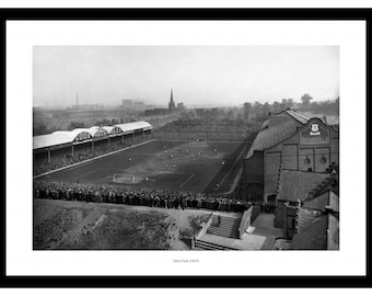 May include: A black and white photograph of a crowded soccer stadium, Villa Park, in 1937. The stadium is filled with spectators, and the field is visible in the center of the image. The stands are packed with people, and the atmosphere is electric.