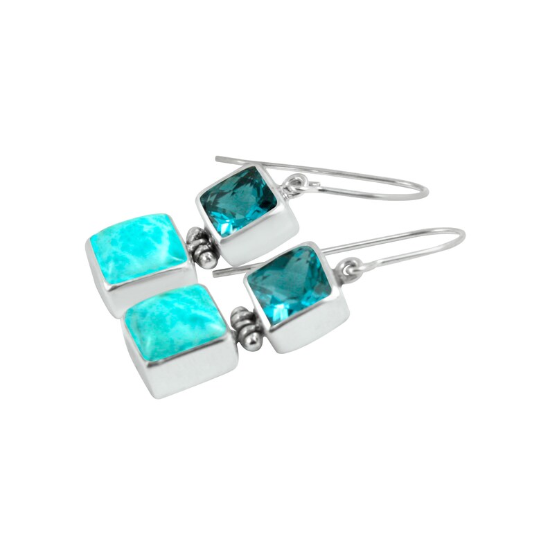 May include: Silver dangle earrings with two square stones. The top stone is a dark blue topaz and the bottom stone is a light blue turquoise.