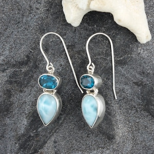 May include: Sterling silver dangle earrings with a teardrop shaped blue lace agate gemstone and a round blue topaz gemstone.
