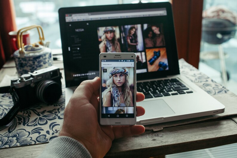 Puede incluir: Un tel&eacute;fono inteligente blanco con una mujer de cabello rubio y ojos azules que lleva una bufanda estampada en la pantalla. El tel&eacute;fono est&aacute; en la mano de una persona.