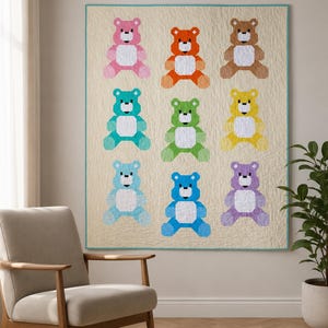 Puede incluir: Una colcha cuadrada que presenta una cuadrícula de nueve osos de peluche pixelados en varios colores, incluyendo rosa, naranja, marrón, verde azulado, verde, amarillo, azul claro, azul y morado, sobre un fondo crema con un borde fino.