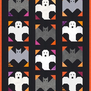 May include: A quilt featuring a grid of twelve alternating blocks displaying stylized white ghosts and grey bats. The blocks are set against a black background with a thin orange border. Each corner of the blocks features small orange, pink, or purple accents.