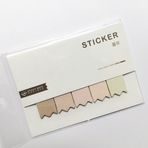 May include: A pack of six pastel colored sticky notes with a scalloped edge. The notes are in shades of brown, pink, and green. The pack is labeled "STICKER" and "藝年".