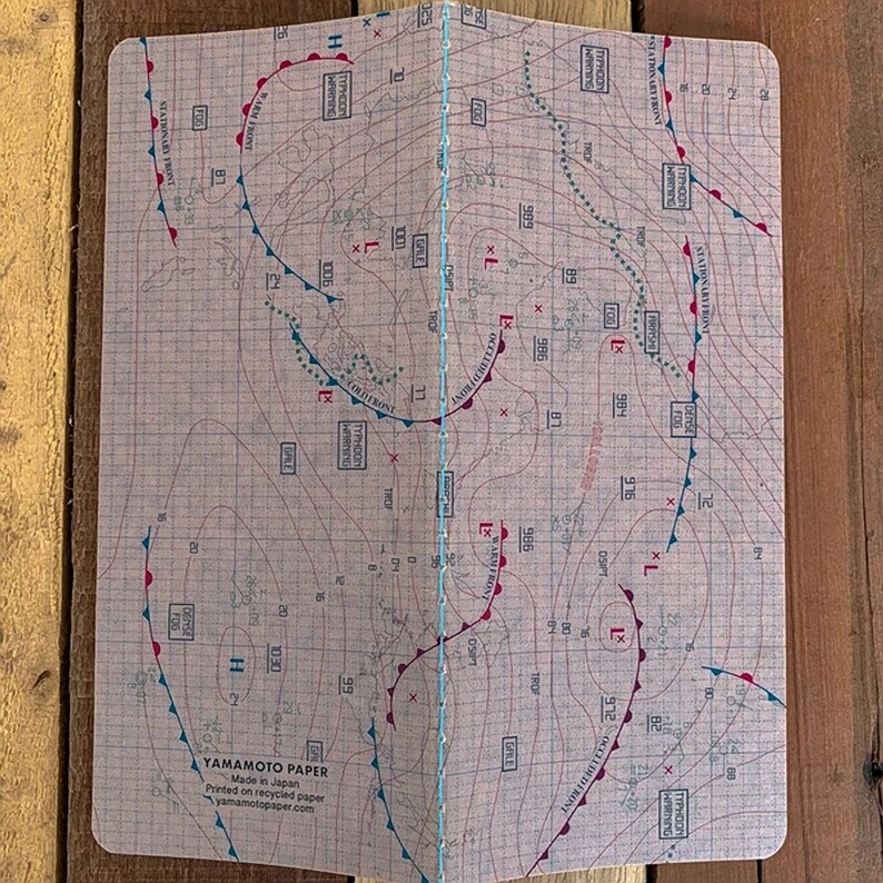 May include: A weather map printed on recycled paper with red and blue lines and markings. The map shows a stationary front, a typhoon, and a trough. The text "YAMAMOTO PAPER" is printed in the bottom left corner.