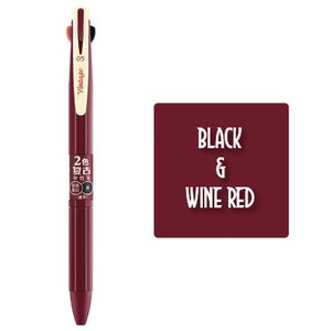 Könnte beinhalten: Ein schwarzer und weinroter, einziehbarer Mehrfarbenstift im Vintage-Design. Der Stift hat drei Schreibspitzen und trägt die Aufschriften "Vintage 05" und "2色 复古" auf dem Schaft.