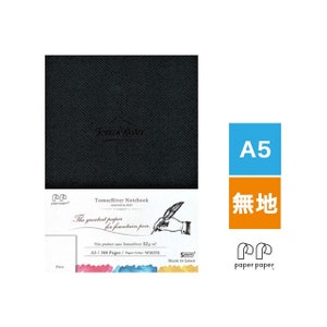 May include: A black notebook with the text "TomoeRiver Notebook" and "The greatest paper for fountain pen" printed on the front cover. The notebook is A5 size and has 368 pages. The paper colour is white.