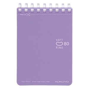 Può includere: Un quaderno viola con una rilegatura ad anelli morbida. Il quaderno misura 105 x 76 mm e ha righe di 6 mm con punti. Il quaderno ha il testo "SOFT RING 80" stampato sulla copertina.