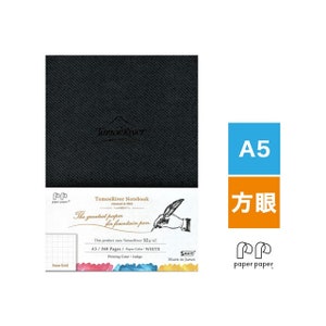 May include: A black notebook with the text "TomoeRiver Notebook" and "The greatest paper for fountain pen" printed on the front cover. The notebook is A5 size and has 368 pages. The paper is white and the printing color is indigo.