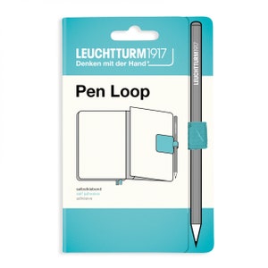 May include: A turquoise blue package for a pen loop for a notebook. The package shows a notebook with a pen loop and the text "Pen Loop" and "LEUCHTTURM1917".