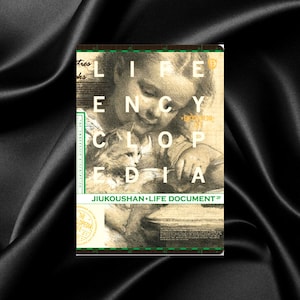Pode incluir: Uma capa de livro com uma ilustração em preto e branco de uma criança segurando um pequeno animal. O título do livro é "Life Encyclopedia" em letras verdes. O livro faz parte da série "Jikoushan Life Document".