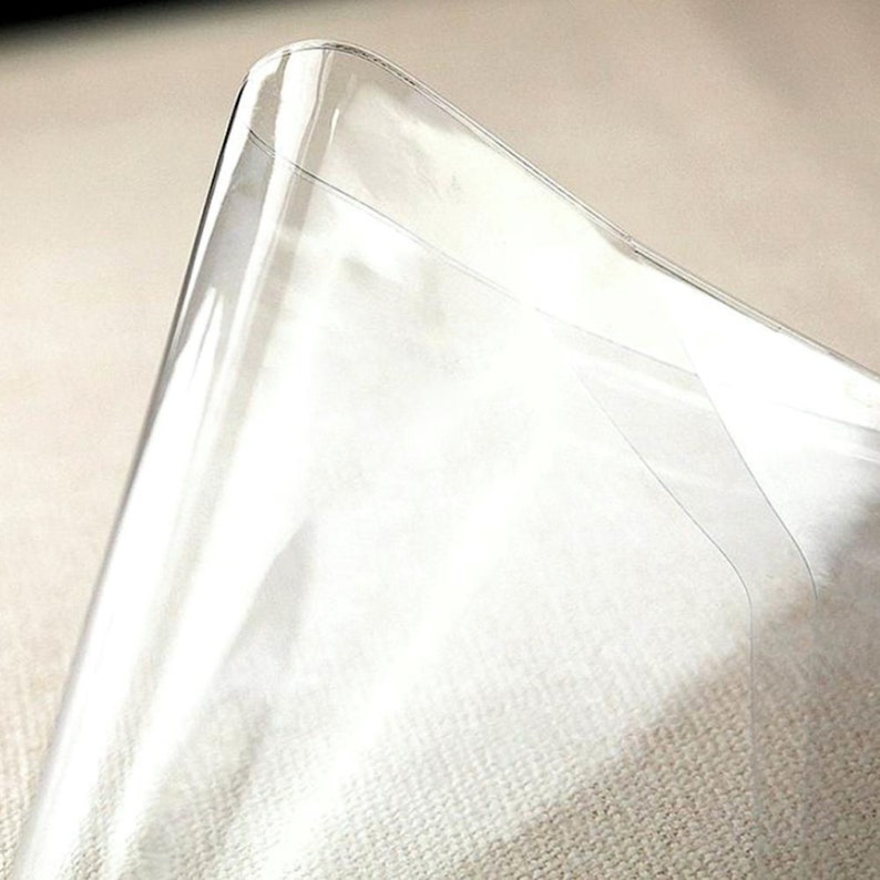 Puede incluir: Hoja de pl&aacute;stico transparente con una ligera curva, que muestra la textura del material.