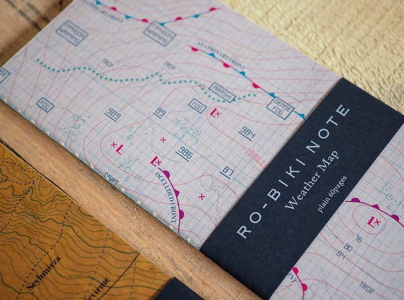 May include: A black and white weather map notebook with the text "RO-BIKI NOTE Weather Map plain 60pages" on the cover. The notebook is open to a page with a weather map with lines, symbols, and text.