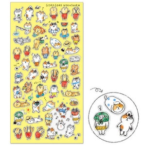 Puede incluir: Una hoja de pegatinas amarillas con gatos de dibujos animados en varios atuendos y poses. Las pegatinas representan gatos pescando, con trajes de baño y con monos. El texto "GORO GORO NYANSUKE" está en la parte superior.