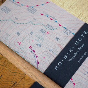 May include: A black and white weather map notebook with the text "RO-BIKI NOTE Weather Map plain 60pages" on the cover.