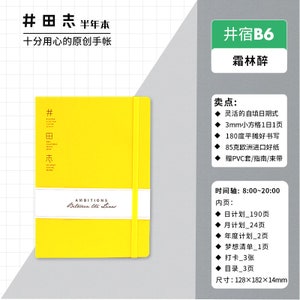 May include: A yellow half-year planner with the text "#田志" and "AMBITIONS Between the Lines" on the cover. The planner is 128 x 182 x 14 mm in size and has a yellow elastic band.