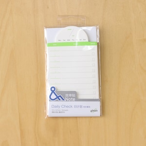 May include: A white notepad with a green and white border. The notepad has a daily check list with a section for Monday through Sunday. The notepad also has a section for things to do and a check list. The notepad is packaged in a clear plastic bag. The notepad is labeled "Daily Check 日计划 待办事项" and "效率贴 Note".