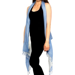 May include: A woman wearing a black tank top and a light blue scarf with white fringe.