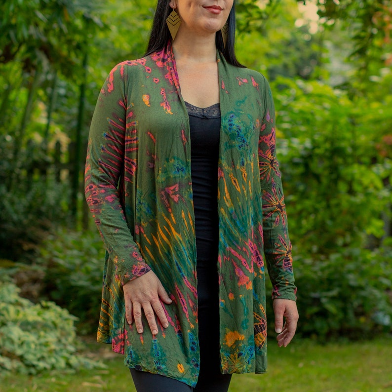 Puede incluir: Una chaqueta de punto verde, rosa y azul con estampado tie-dye, mangas largas y abertura frontal. La chaqueta est&aacute; hecha de una tela suave y ligera y tiene un corte holgado.
