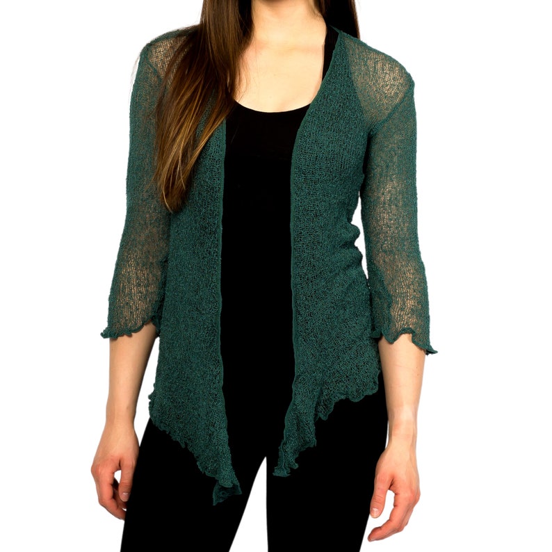 Op de afbeelding: Een tealgroene open cardigan met een gerimpelde zoom en driekwart mouwen.